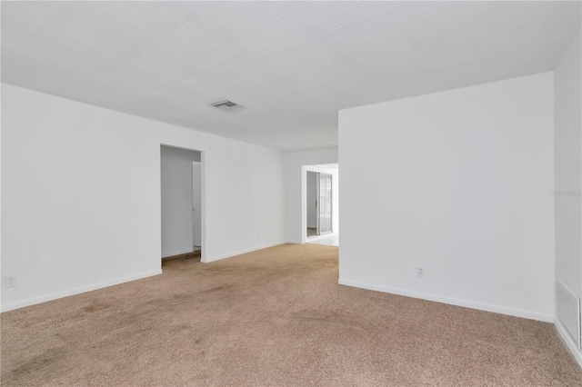 empty room featuring light carpet and a textured ceiling