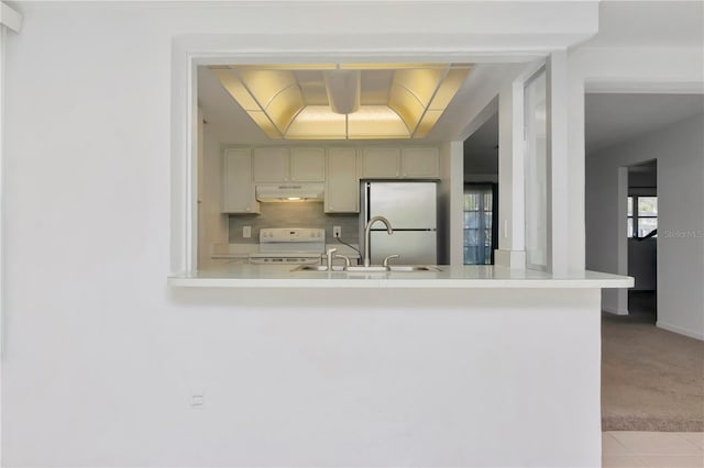 kitchen featuring backsplash, sink, white range with electric cooktop, light carpet, and refrigerator