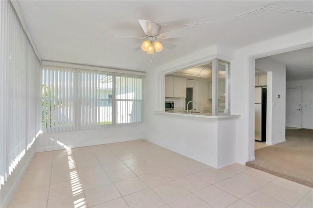 empty room with ceiling fan, light tile floors, and sink