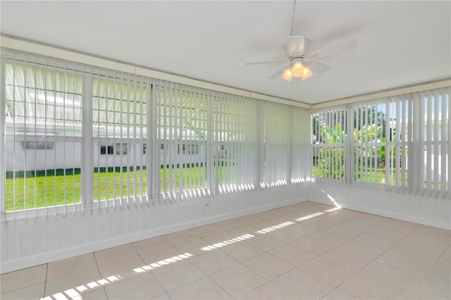 unfurnished sunroom featuring ceiling fan and a wealth of natural light