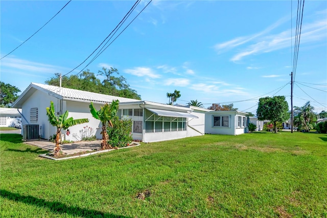 back of house featuring central AC unit and a yard