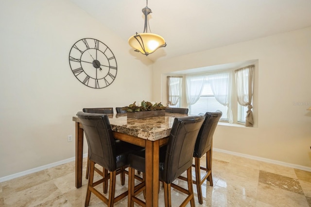 tiled dining area with lofted ceiling