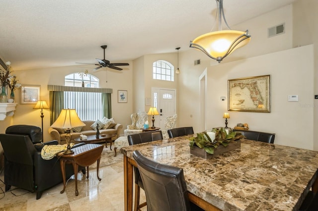 dining area featuring high vaulted ceiling, a textured ceiling, ceiling fan, and light tile floors