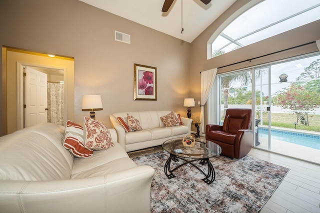 living room with high vaulted ceiling, hardwood / wood-style floors, and ceiling fan