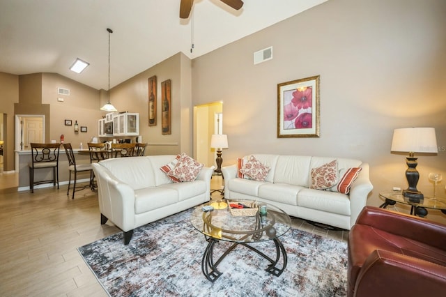 living room featuring high vaulted ceiling, ceiling fan, and light hardwood / wood-style flooring