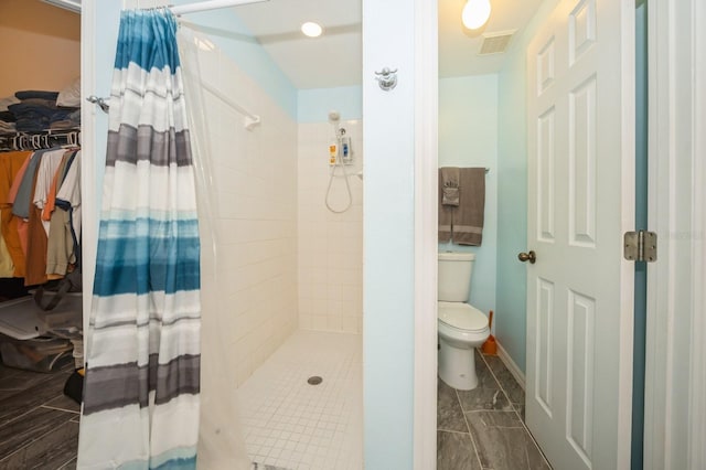 bathroom featuring curtained shower, toilet, and tile floors