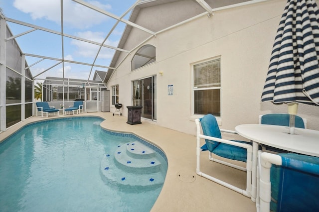 view of swimming pool featuring glass enclosure and a patio