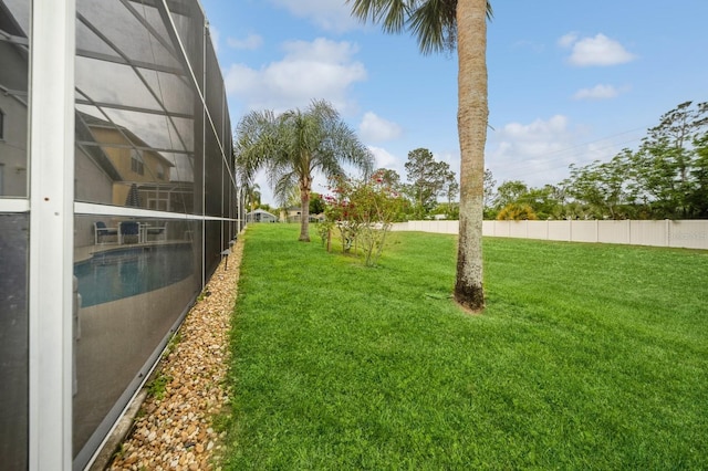 view of yard with a fenced in pool and glass enclosure