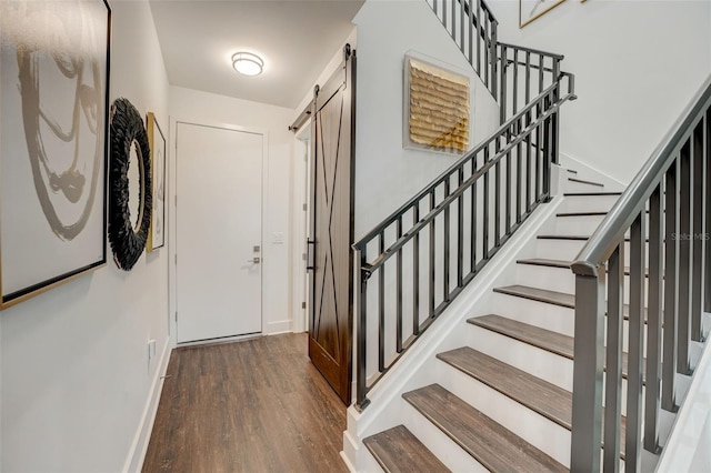 entryway with dark hardwood / wood-style flooring and a barn door