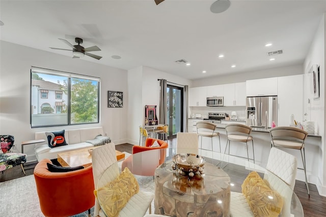 living room featuring ceiling fan and dark hardwood / wood-style floors