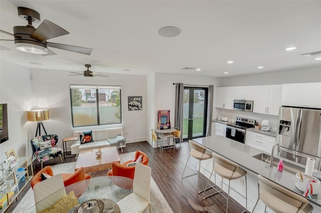 living room featuring dark hardwood / wood-style floors, a healthy amount of sunlight, and ceiling fan