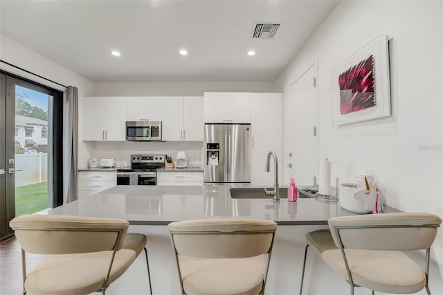 kitchen featuring white cabinetry, a breakfast bar area, and stainless steel appliances