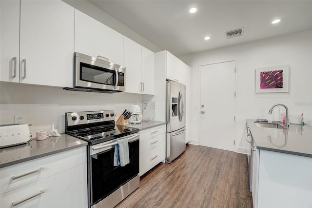 kitchen with white cabinetry, dark wood-type flooring, sink, and stainless steel appliances