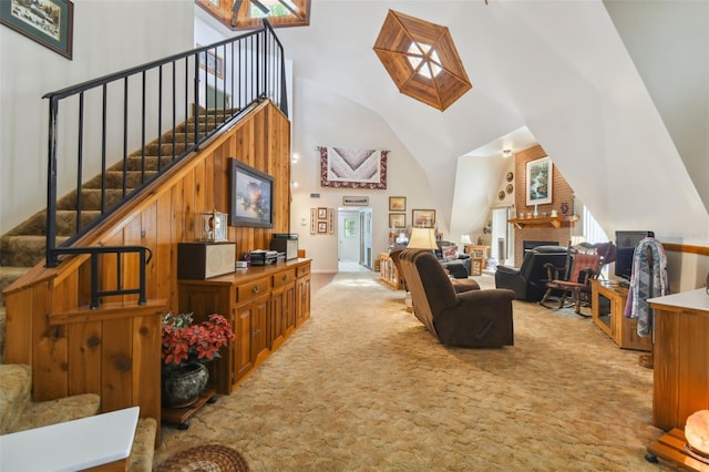 living room with a skylight, a fireplace, light colored carpet, and a high ceiling