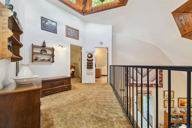 corridor featuring lofted ceiling with skylight and carpet flooring