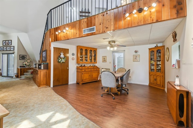 dining room with hardwood / wood-style flooring, ceiling fan, and a high ceiling