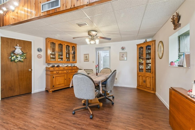 dining room featuring a drop ceiling, wood-type flooring, and ceiling fan