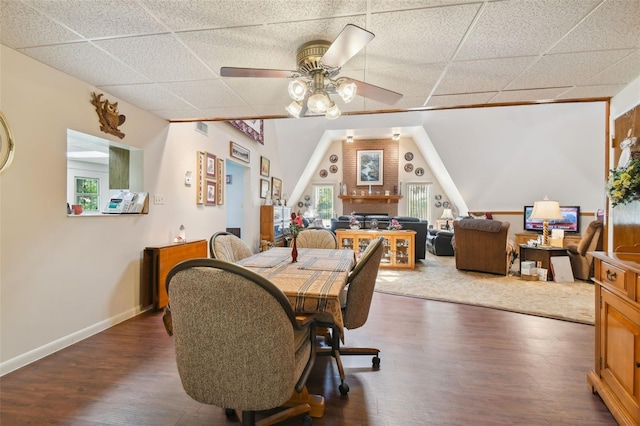 dining room featuring ceiling fan, dark hardwood / wood-style flooring, and a drop ceiling