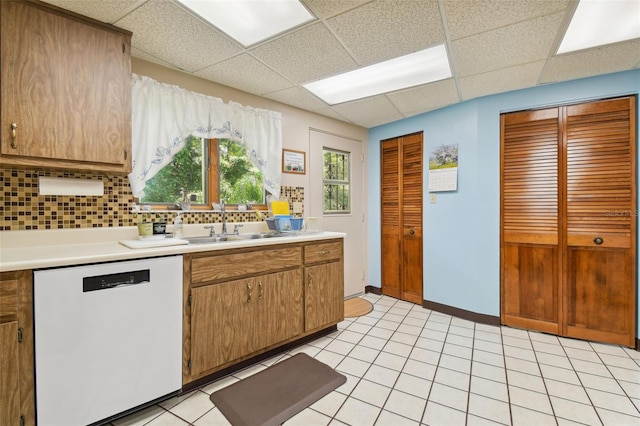 kitchen with dishwasher, light tile floors, and a paneled ceiling