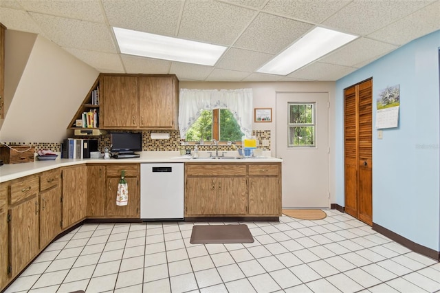 kitchen with sink, dishwasher, light tile flooring, and a paneled ceiling