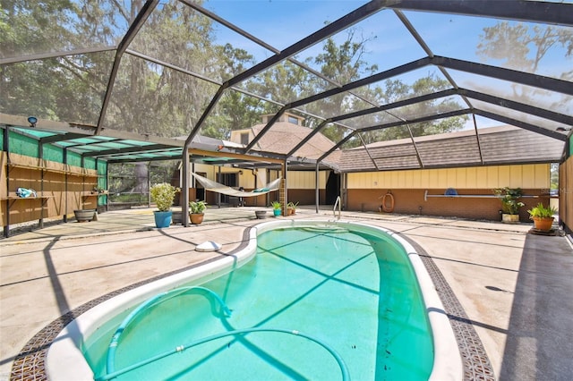 view of swimming pool with glass enclosure and a patio