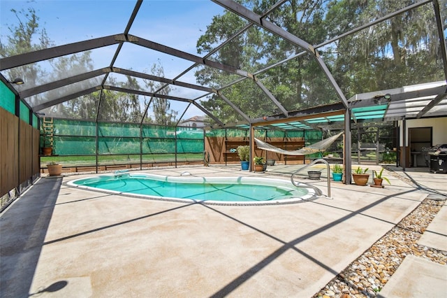 view of swimming pool featuring glass enclosure and a patio