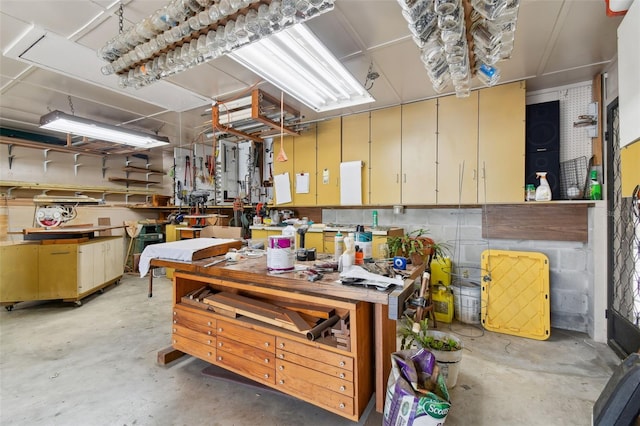 miscellaneous room featuring concrete flooring and a workshop area