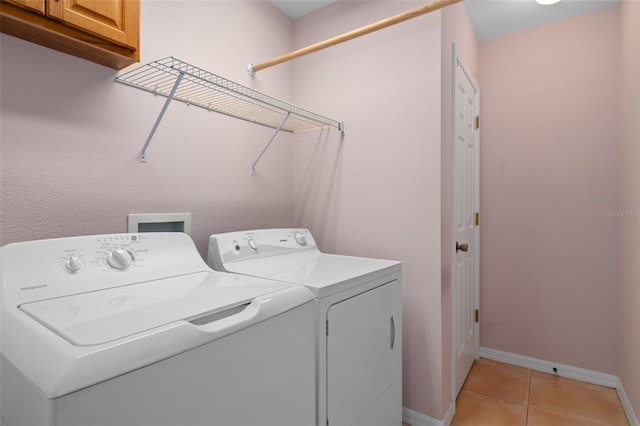 clothes washing area featuring independent washer and dryer, cabinets, washer hookup, and light tile flooring