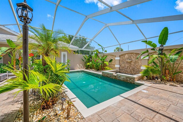 view of pool with a patio and glass enclosure