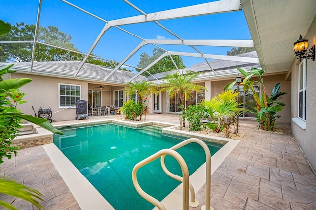 view of swimming pool with glass enclosure and a patio area