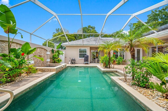 view of pool with a patio area and glass enclosure