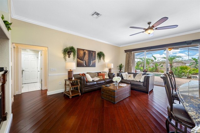 living room with ceiling fan, dark hardwood / wood-style flooring, and ornamental molding