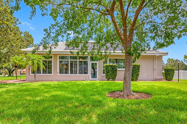 rear view of house featuring a lawn