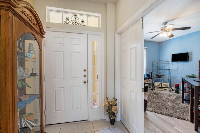 entryway with light tile floors and ceiling fan