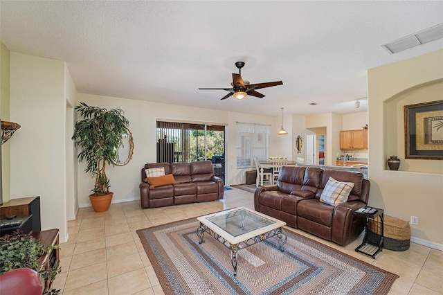 tiled living room featuring a textured ceiling and ceiling fan