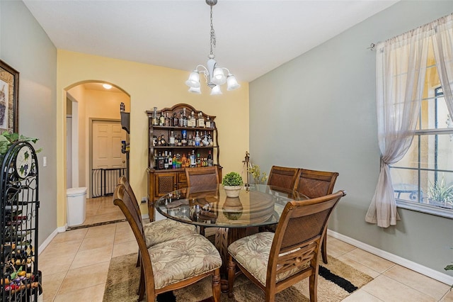 tiled dining area with an inviting chandelier and plenty of natural light