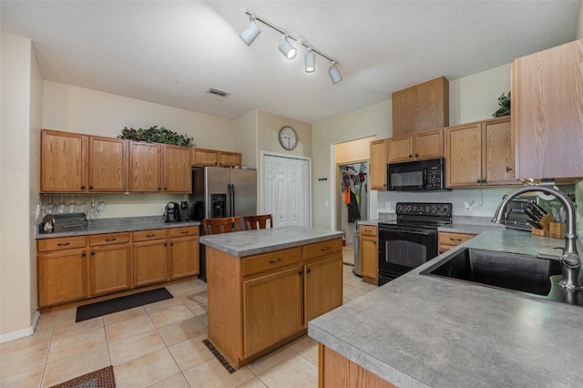 kitchen with a center island, a textured ceiling, sink, rail lighting, and black appliances