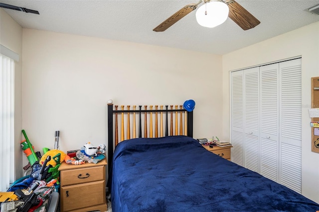 bedroom featuring ceiling fan, a closet, and a textured ceiling