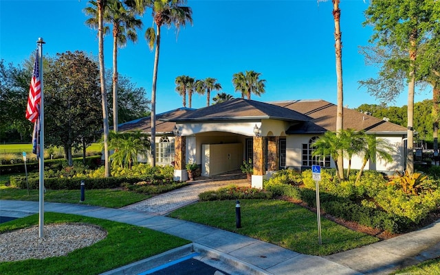 ranch-style home featuring a front lawn and a garage