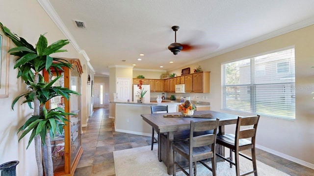 dining room featuring light tile floors, ceiling fan, and crown molding