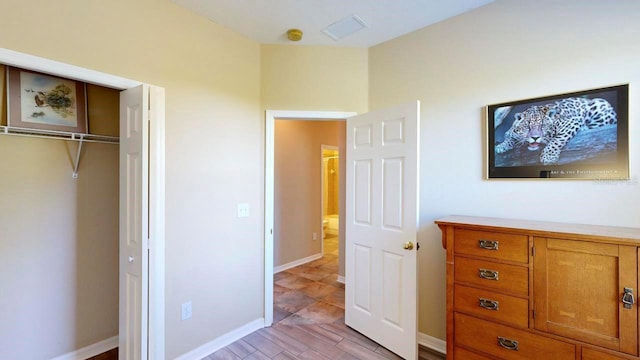 unfurnished bedroom featuring light tile floors and a closet