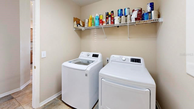 laundry room with light tile floors and washing machine and clothes dryer