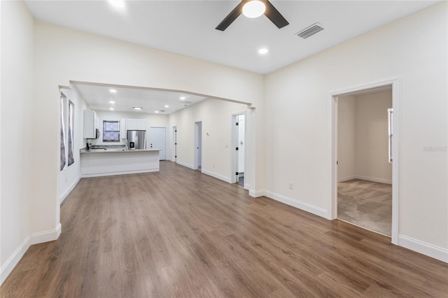 unfurnished living room featuring hardwood / wood-style floors and ceiling fan