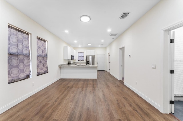 unfurnished living room featuring sink and dark hardwood / wood-style floors