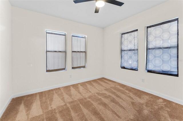 carpeted spare room with ceiling fan