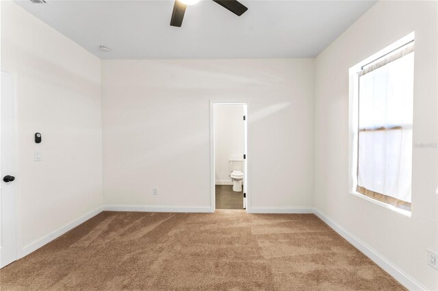 carpeted spare room featuring ceiling fan and a healthy amount of sunlight