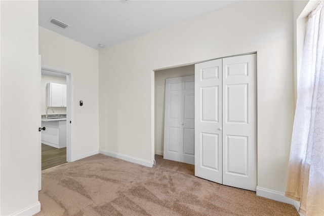 unfurnished bedroom featuring a closet and light carpet