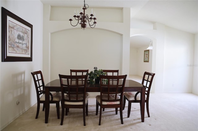 dining room with lofted ceiling, light carpet, and an inviting chandelier