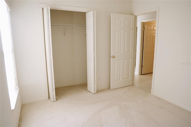 unfurnished bedroom featuring a closet and light carpet