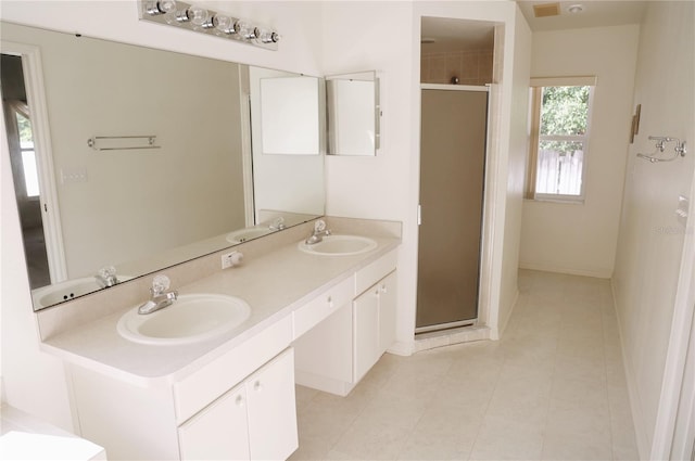 bathroom with dual sinks, a shower with shower door, large vanity, and tile floors